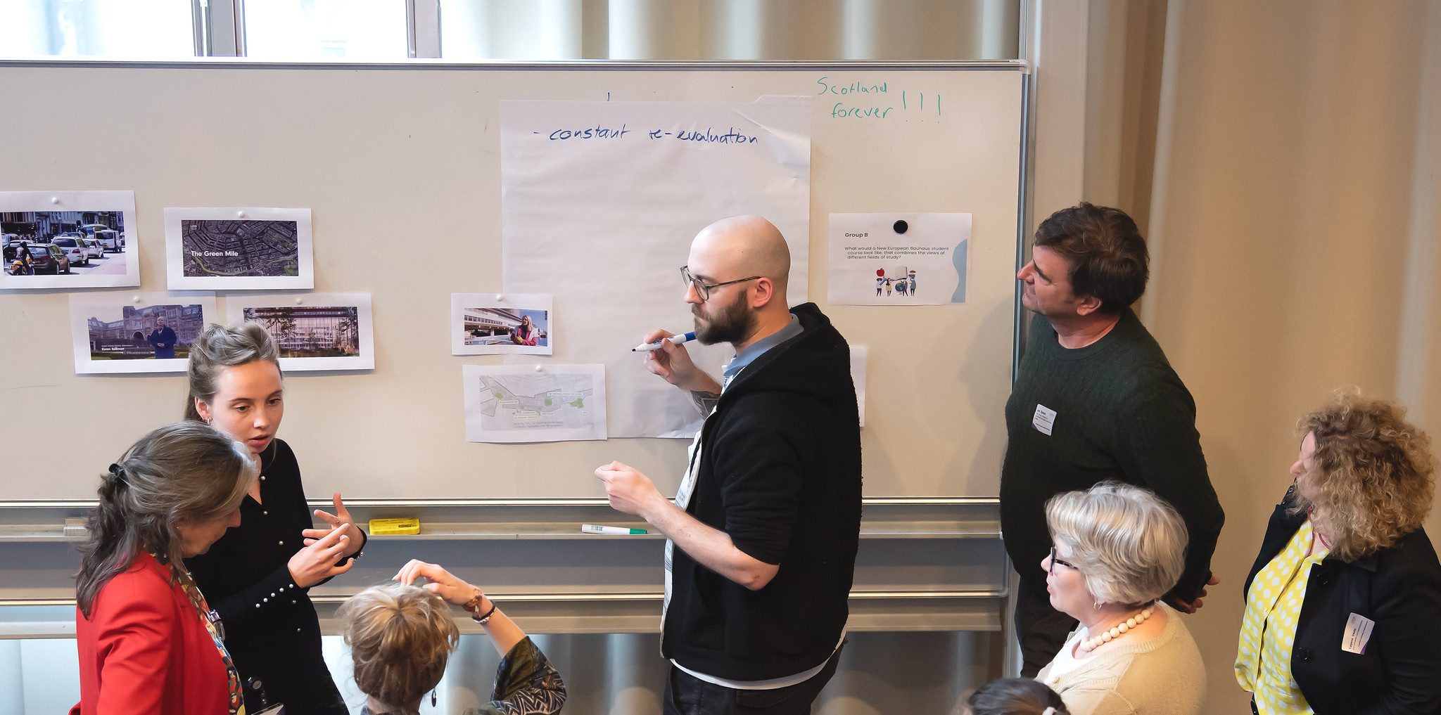 People working together and writing on white board.