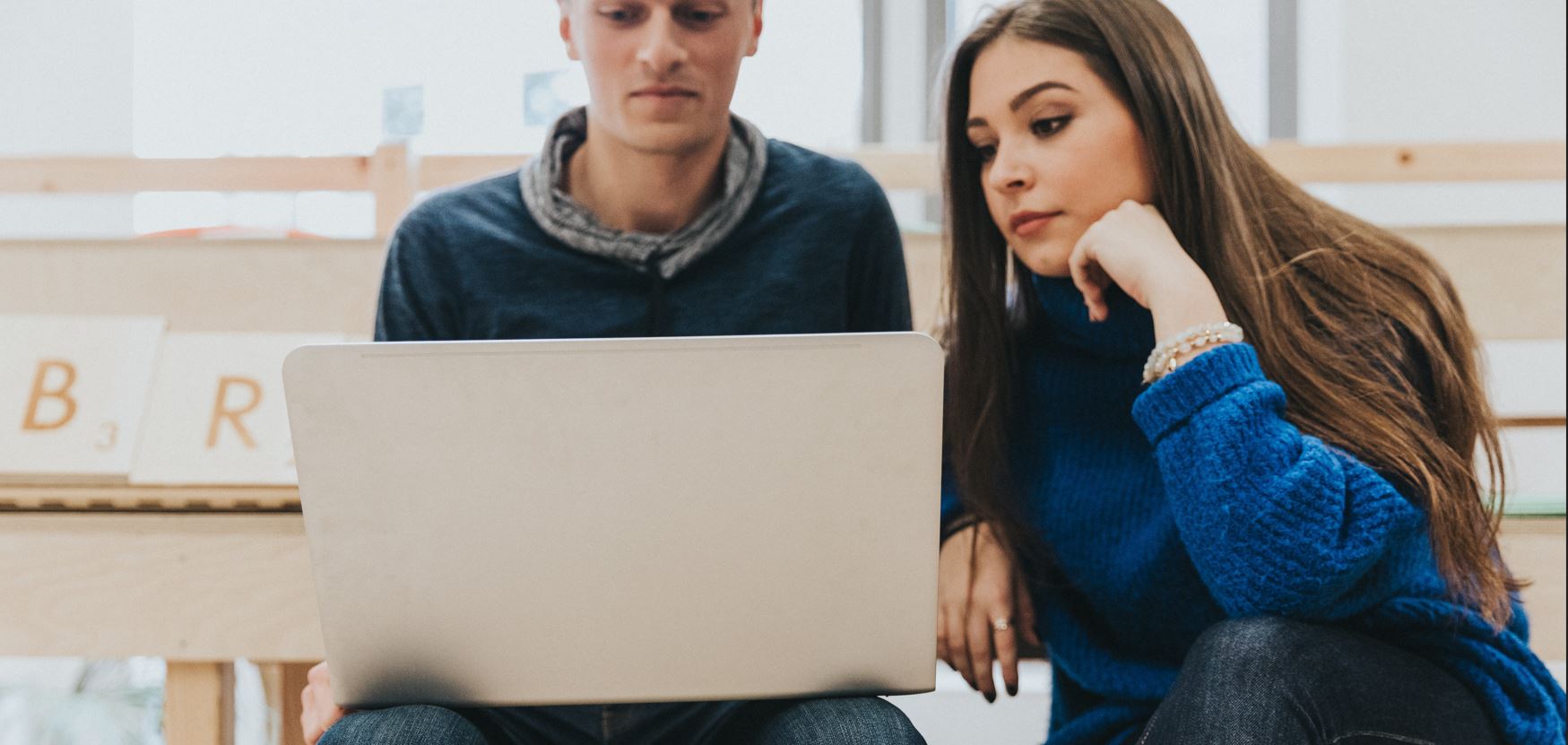 Two students looking at a laptop screen together