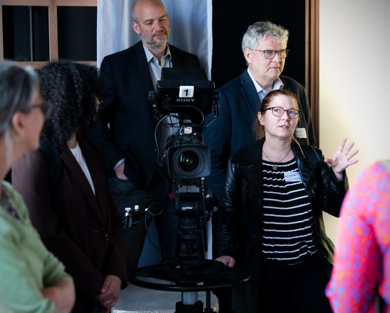People standing around a camera